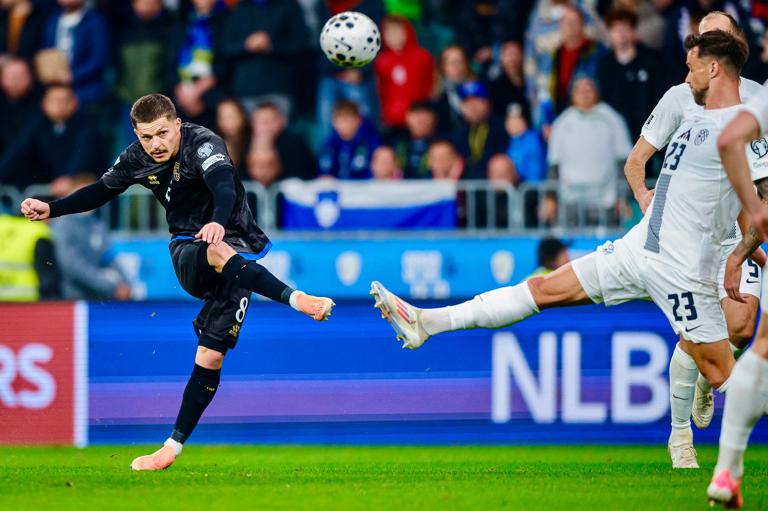 Kosovo's midfielder#08 Florent Muslija (L) shoots towards goal as Slovenia's defender #23 David Brekalo (R) attempts to block the ball during the FIFA World Cup 2026 Group B European qualification football match between Slovenia and Kosovo at the Stozice Stadium in Ljubljana, on November 15, 2025. (Photo by Jure Makovec / AFP)