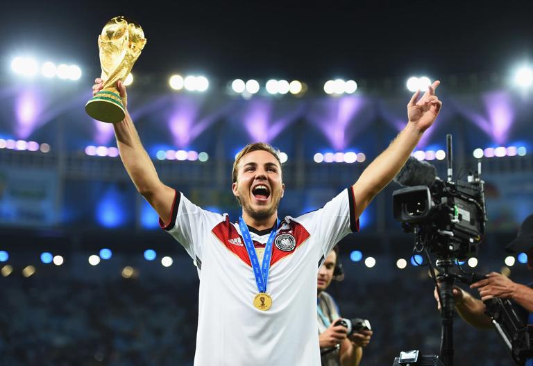 RIO DE JANEIRO, BRAZIL - JULY 13:  Mario Goetze of Germany holds up the World Cup trophy after the 1-0 win in the 2014 FIFA World Cup Brazil Final match between Germany and Argentina at Maracana on July 13, 2014 in Rio de Janeiro, Brazil.  (Photo by Shaun Botterill - FIFA/FIFA via Getty Images)